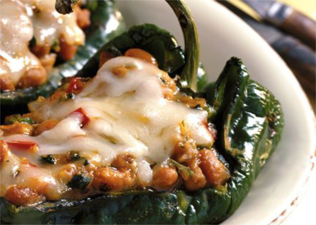Close up of stuffed poblano chile with melted cheese on top