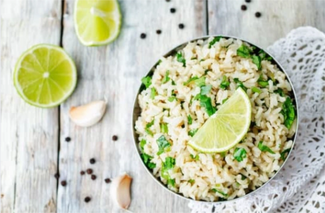 A bowl of cilantro lime rice with a quartered lime on top