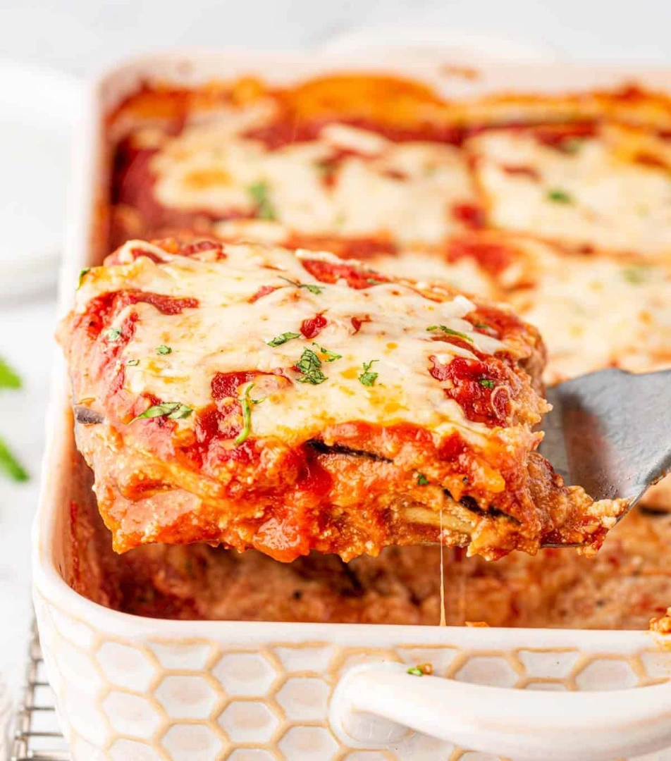 Eggplant lasagna being served out on a ceramic dish