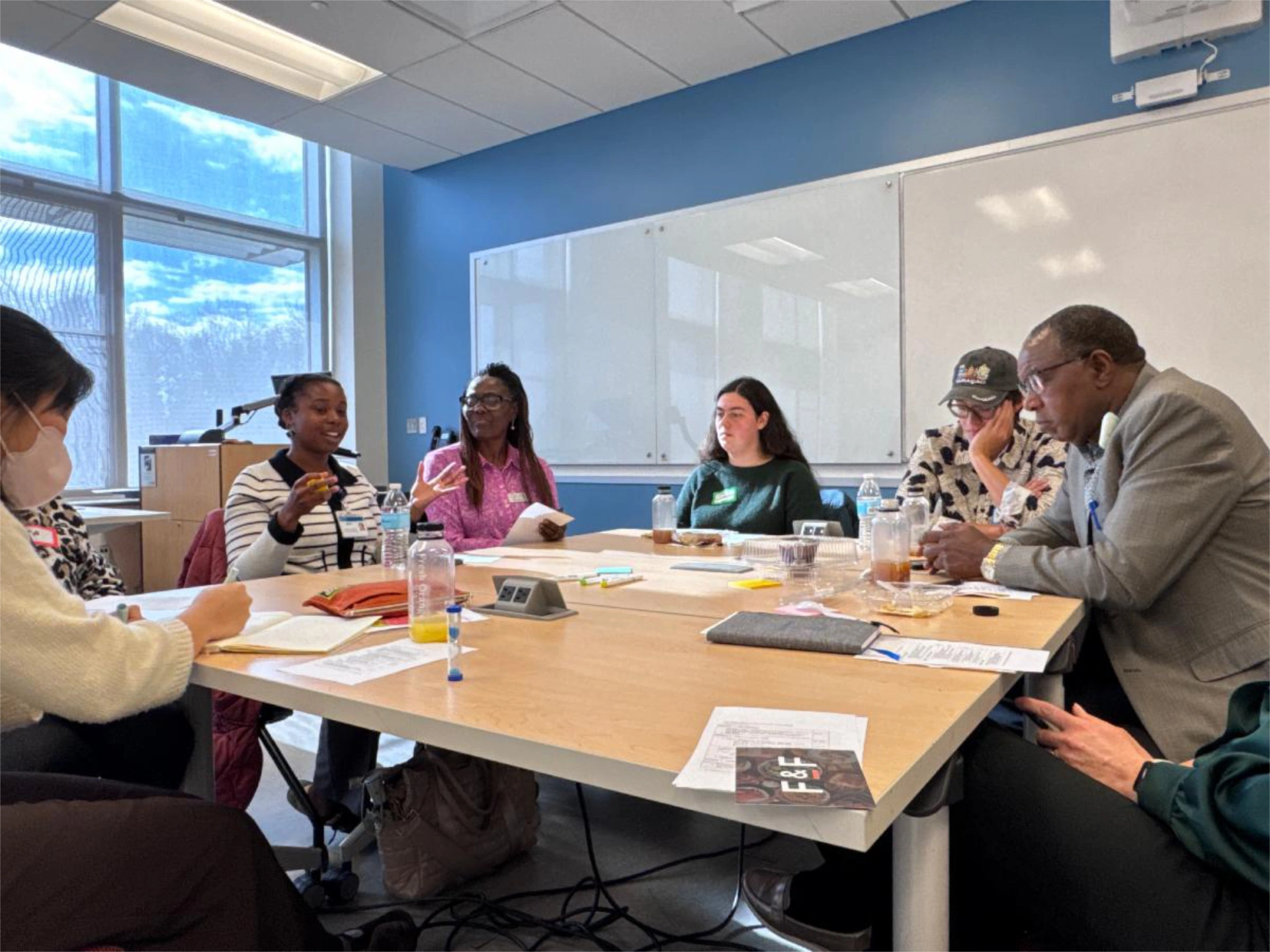 Group of attendees talking around table at Food In Justice event