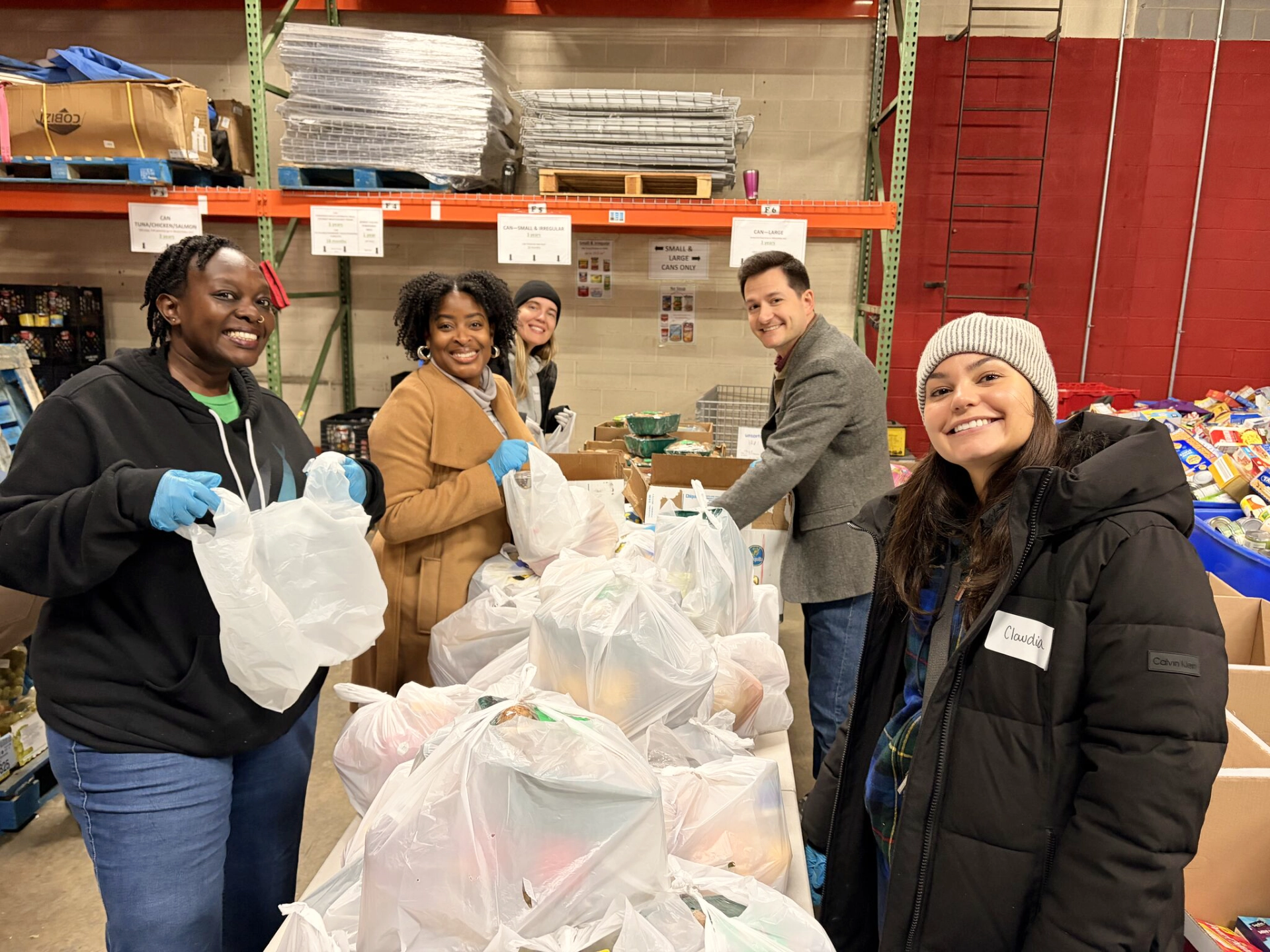 Group of Manna volunteers smiling as they pack bags