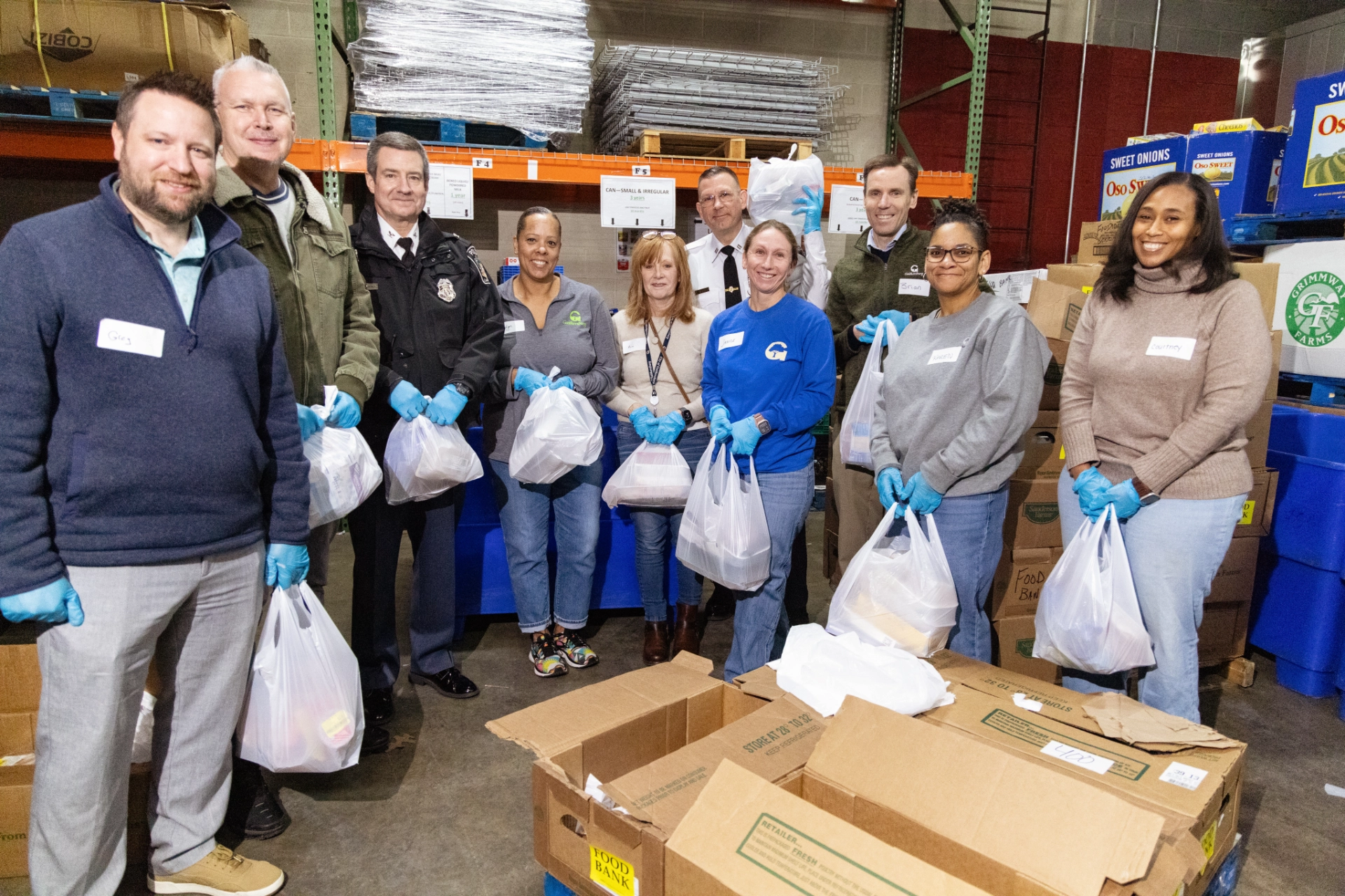 Group of warehouse volunteers with packed bags