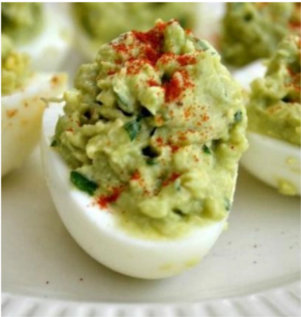A deviled egg with guacamole mixture on top
