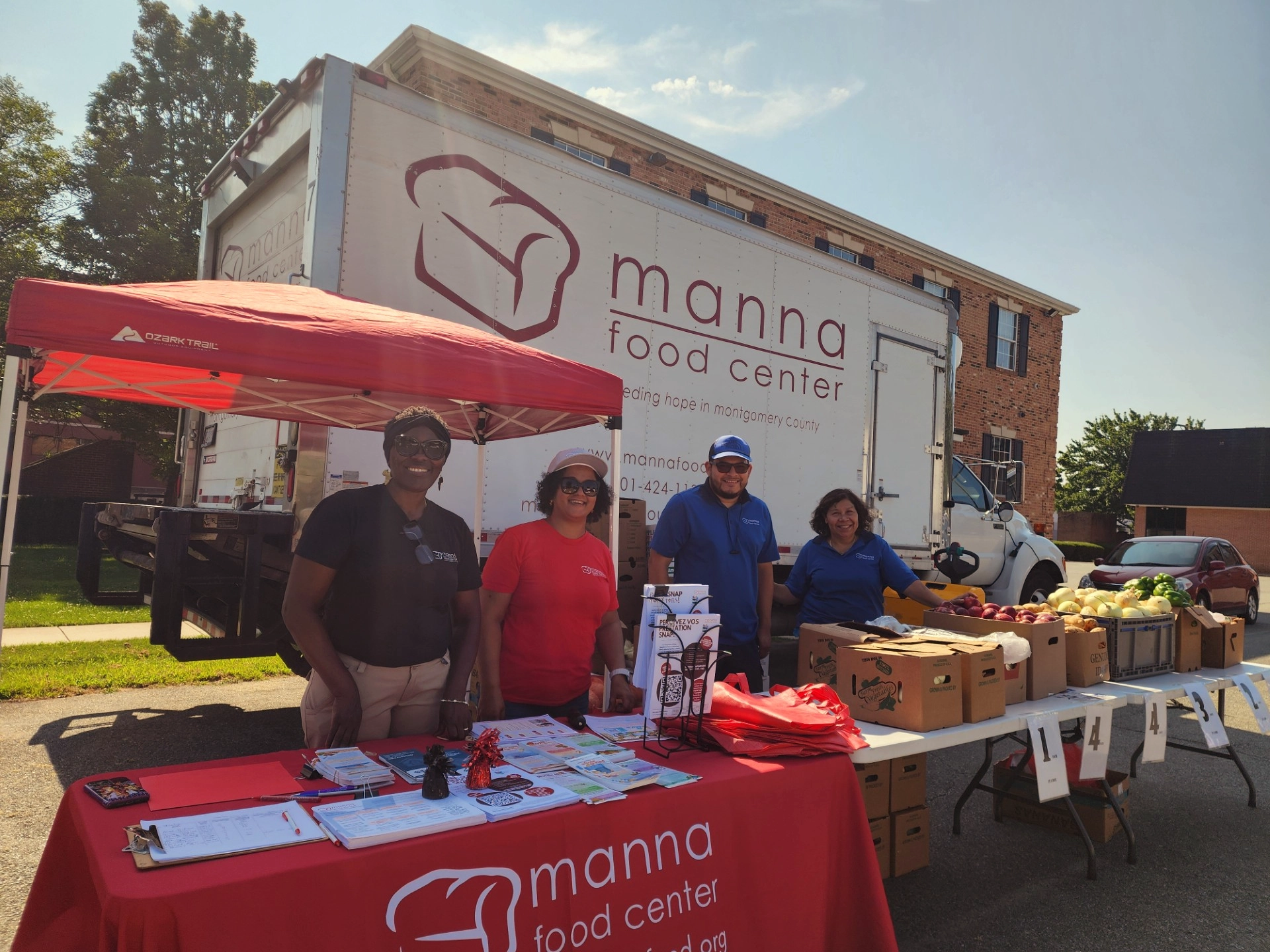 Manna staff at distribution site with Manna truck