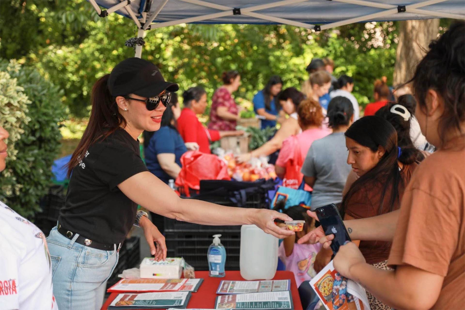 Manna staff handing out fruit cups at event with families