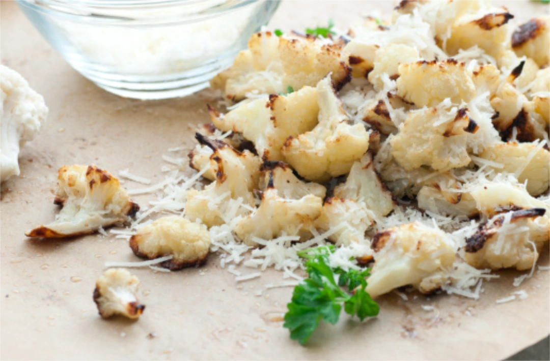 Parmesan cheese on top of roasted cauliflower chunks