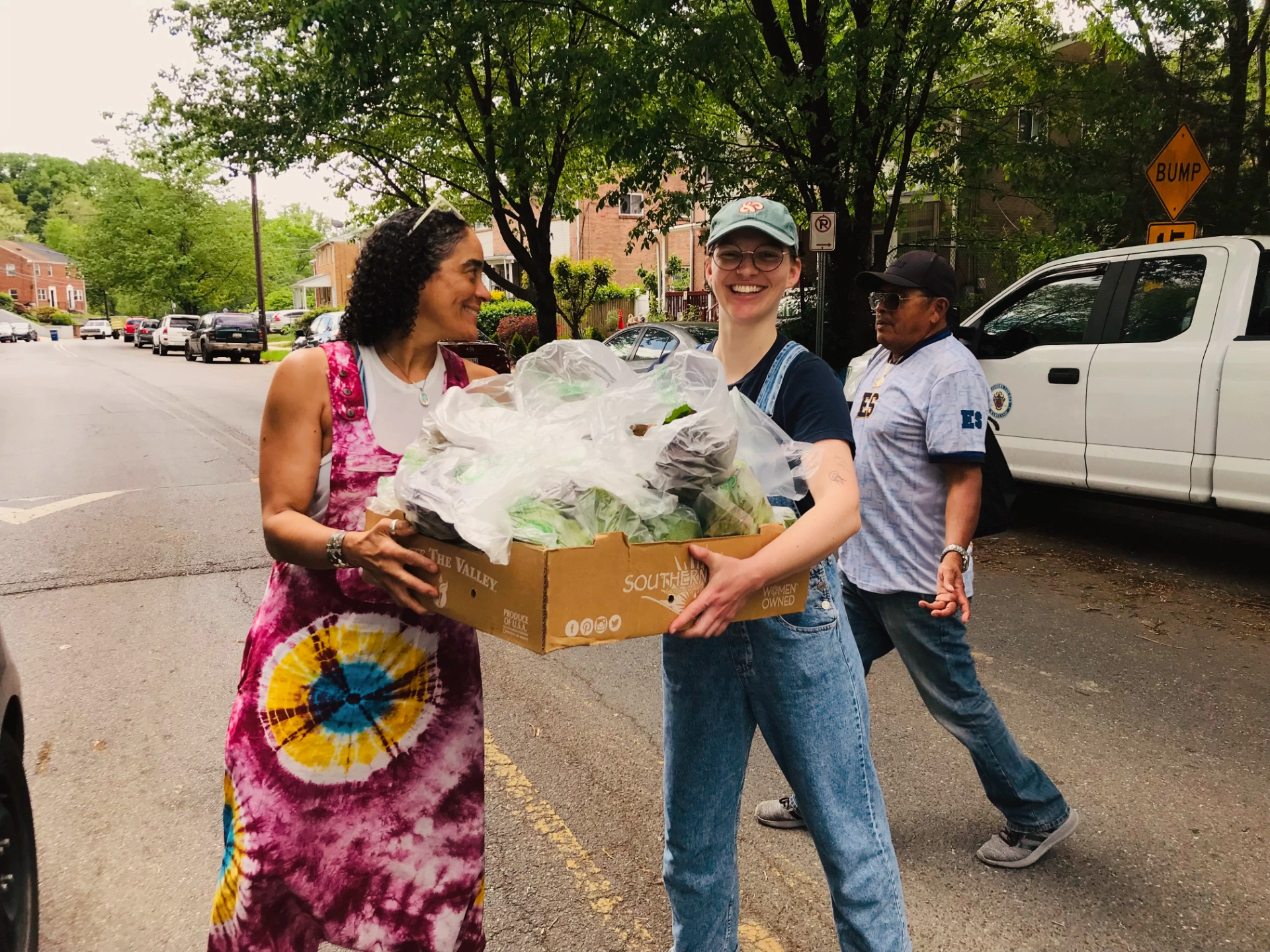 Two people exchanging box of fresh produce for donation