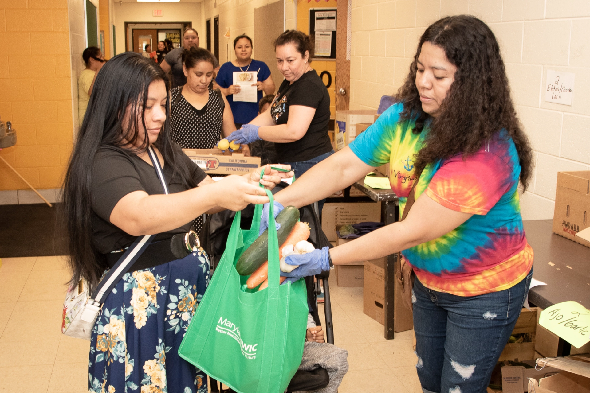 Woman collecting bag of fresh food at school