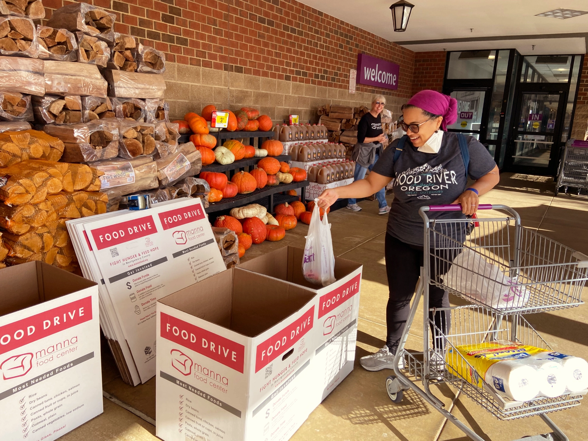 Woman making donation to food drive outside grocery store